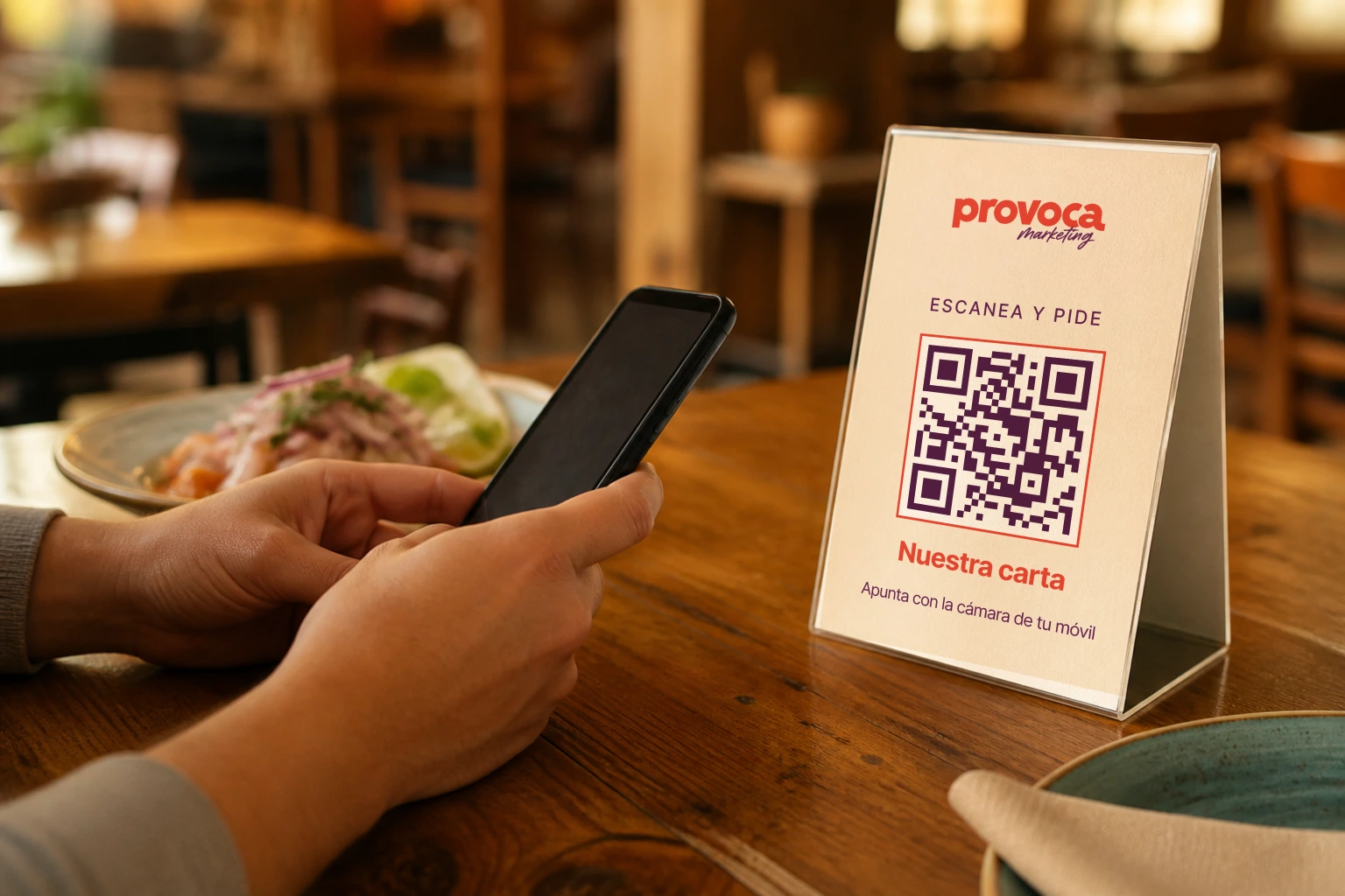 Atril con código QR de Provoca Marketing sobre la mesa de un restaurante, listo para escanear y pedir